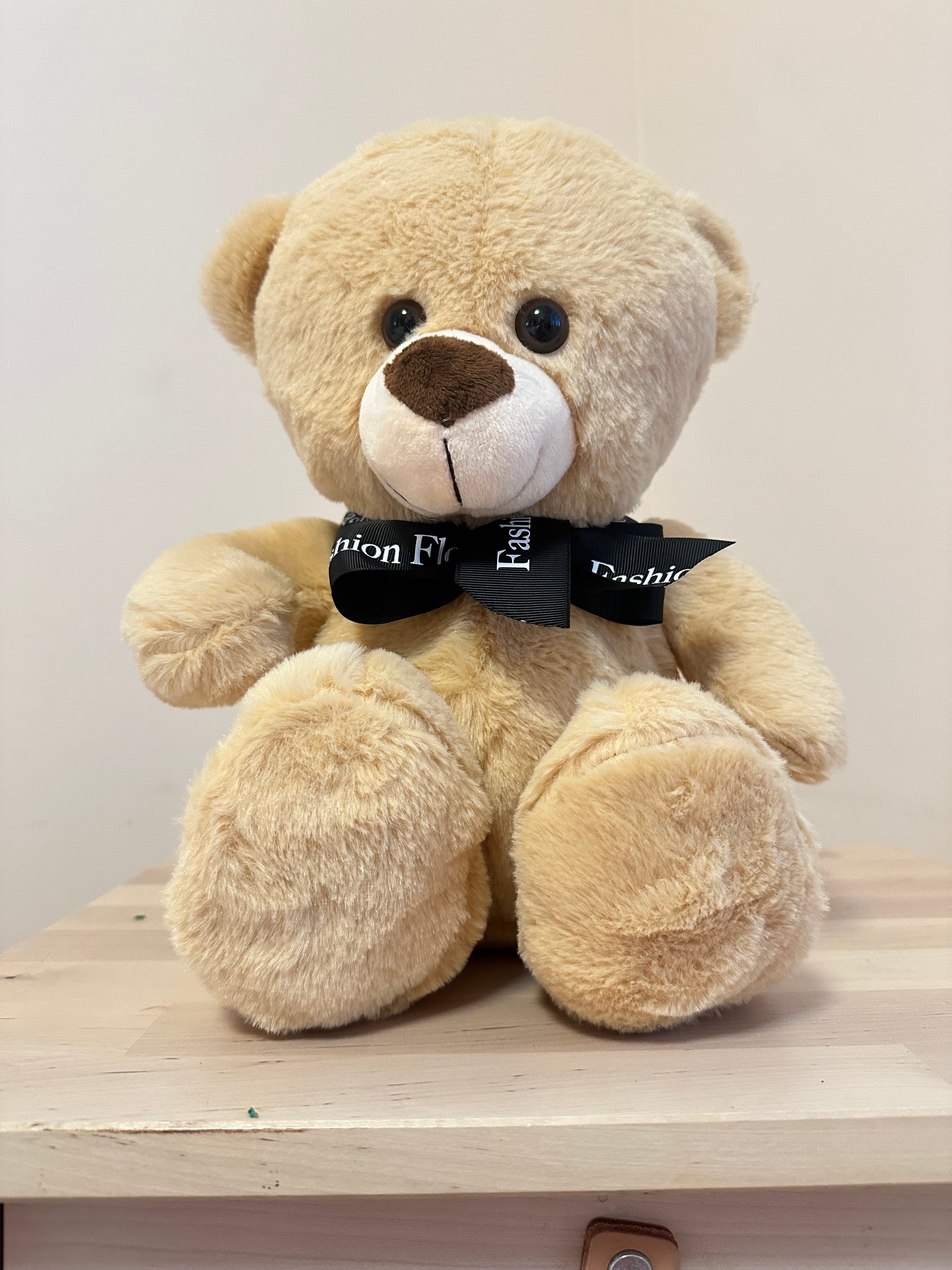 Creamy beige teddy bear with black bow on marble table â limited luxury gift in Miami