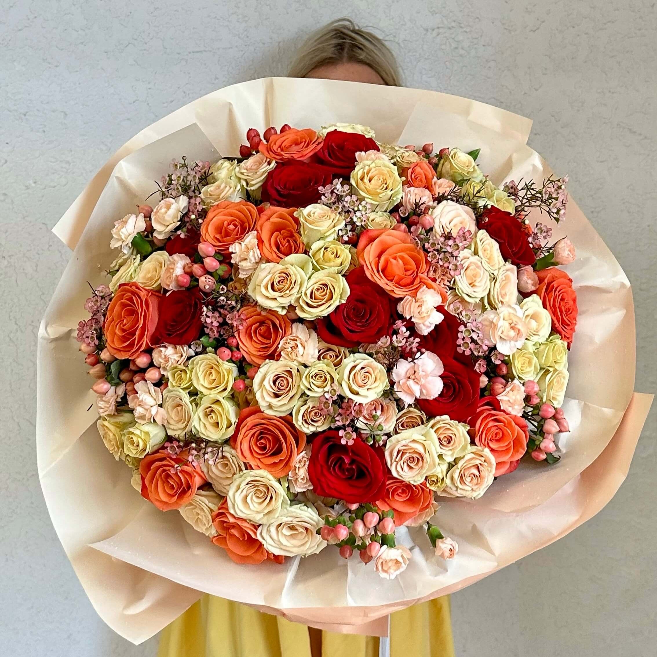 Autumn Shades bouquet with 150 roses in red and peach hues wrapped in yellow paper — luxury gifting in Miami city
