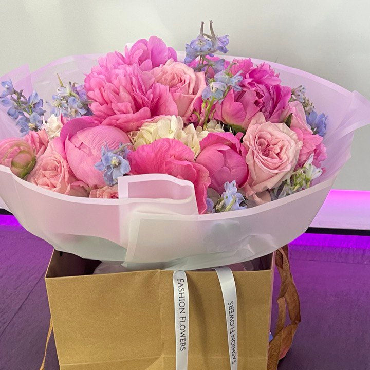 Blooming Melody bouquet with pink peonies and roses — luxury hand-tied flower delivery in a beauty salon, Miami