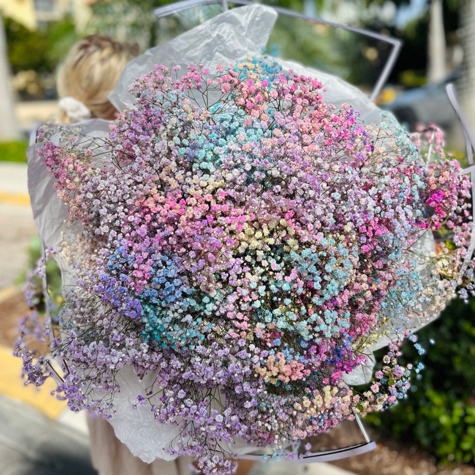 A smiling blonde woman with a bouquet â children's smile in soft pink tones with an authorâs touch.