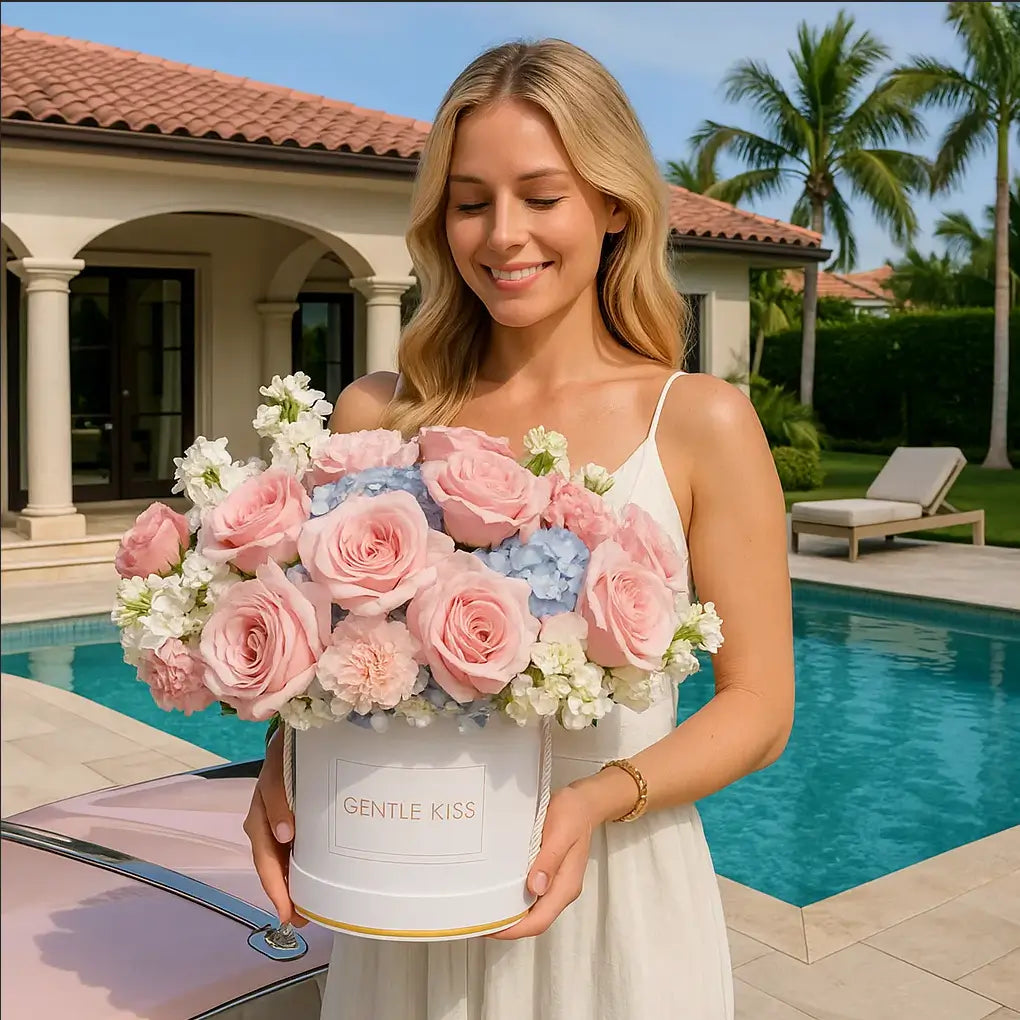 Gentle Kiss white hatbox with soft pink roses and blue hydrangeas by villa and pool â luxury flower delivery Miami