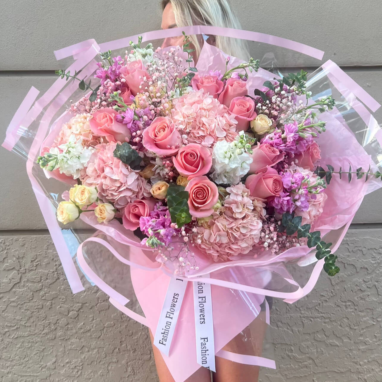 Voluminous hand-tied bouquet with soft pink roses and hydrangeas inside a luxury boutique — flower delivery Miami