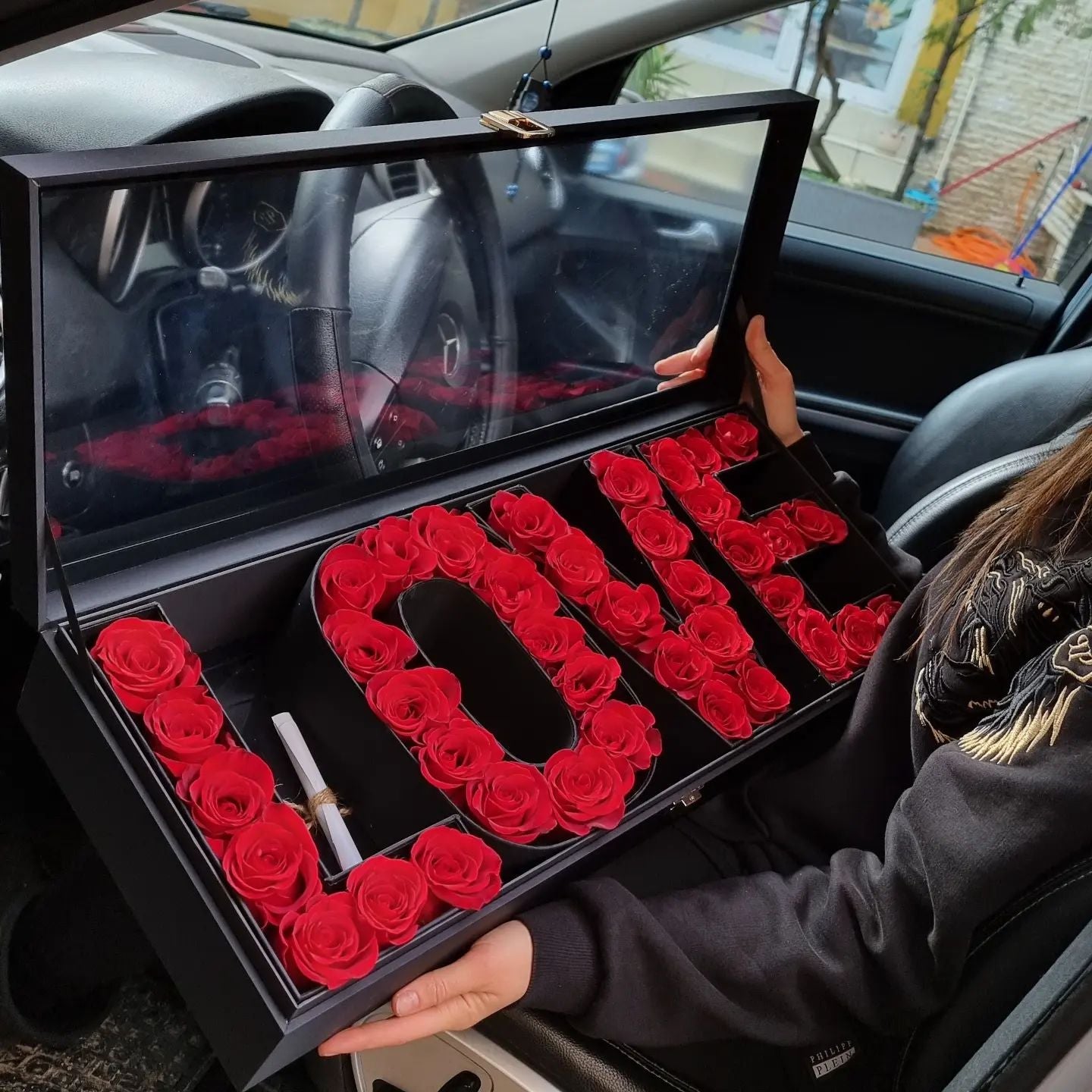 Designer LOVE box with fresh red roses on a car — luxury floral surprise in Miami