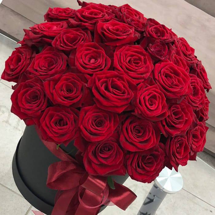 Only Love bouquet of red roses in black box with ribbon held by elegant woman in luxury interior â romantic gift Miami