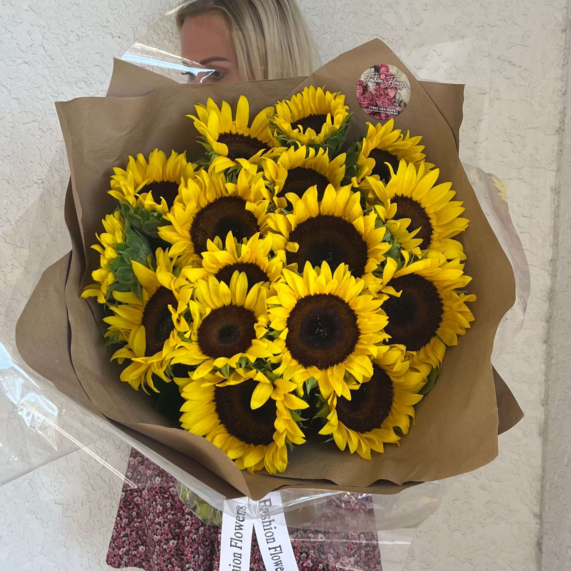 Sunshine bouquet with sunflowers and luxury wrapping held â same-day flower delivery Miami
