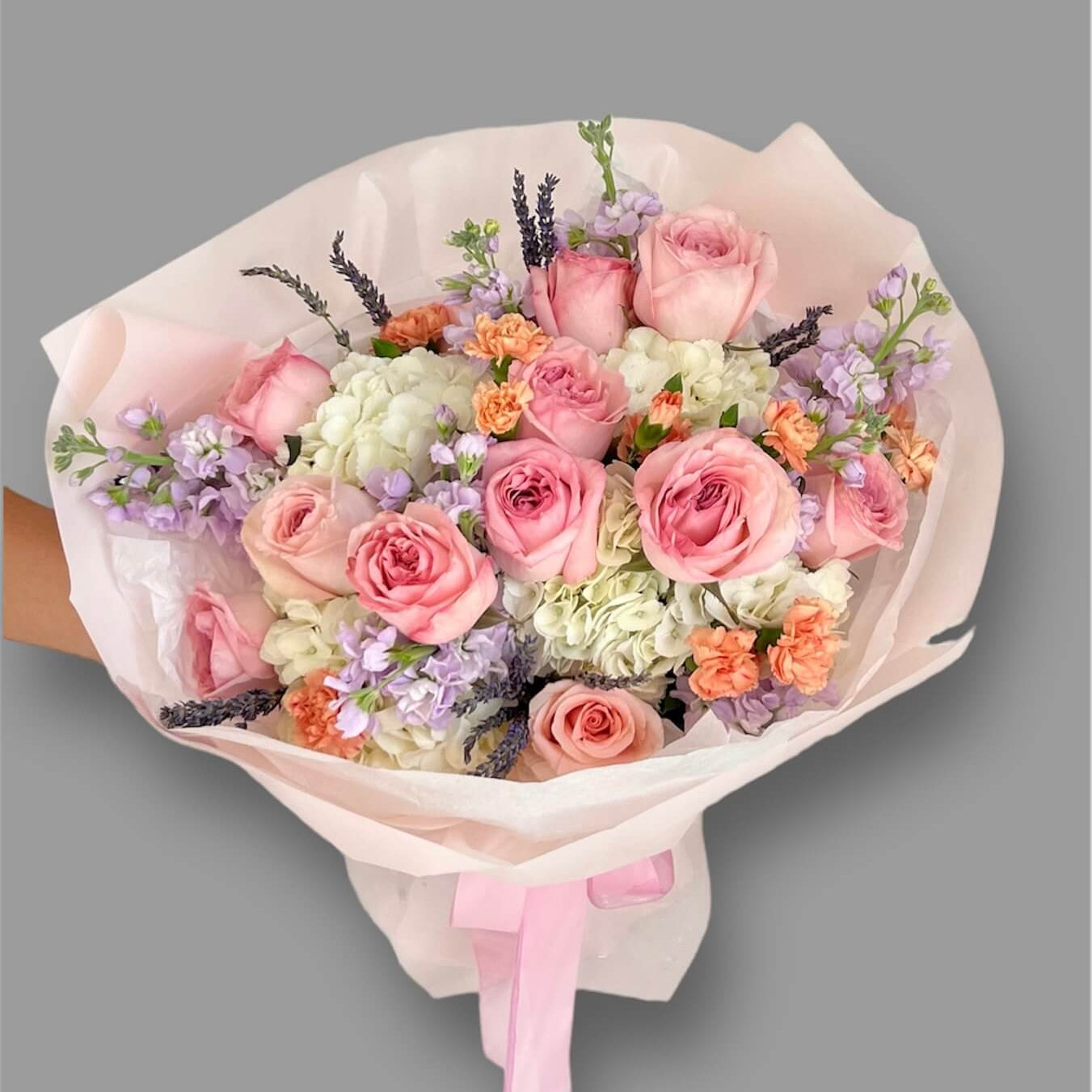 Suzanne hand-tied bouquet with soft pink and peach tones — luxury flower delivery Miami