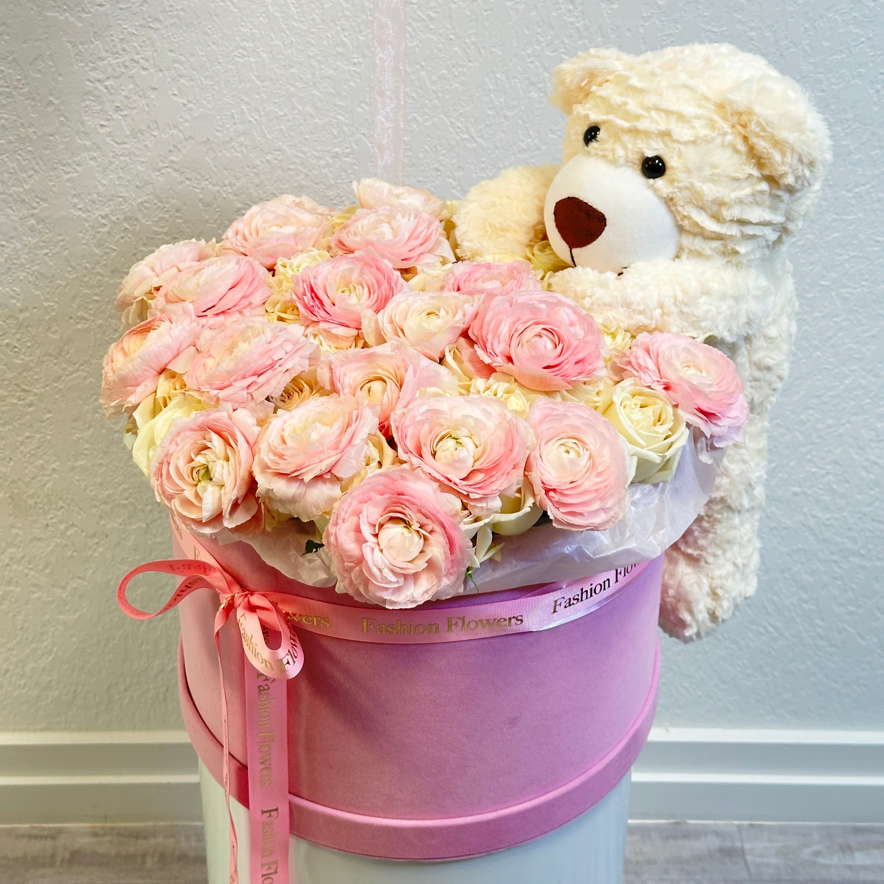 Designer box of pale pink roses with soft white teddy bear on a marble surface â limited luxury gift for romantic occasions