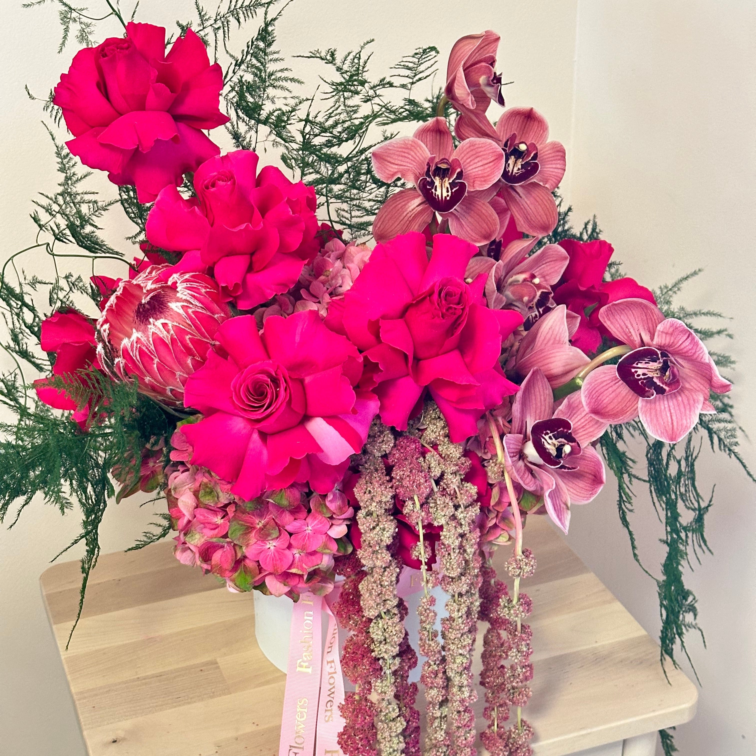 Tropical bouquet with roses, orchids, and anemones in white wrapping â artistic flower delivery in Miami