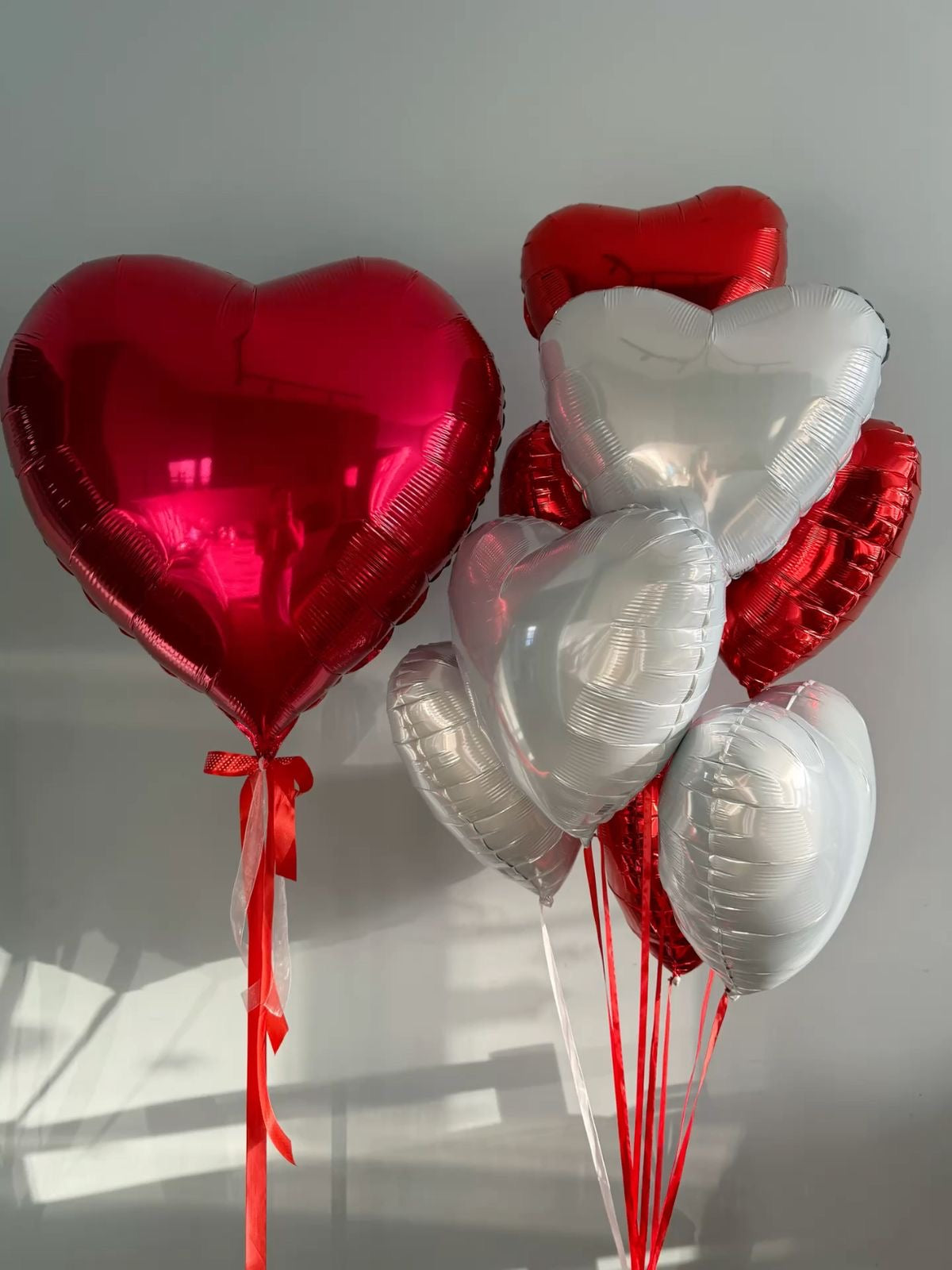 Red & White Hearts: red and white heart-shaped foil balloons, ribbons in a heart balloon bouquet