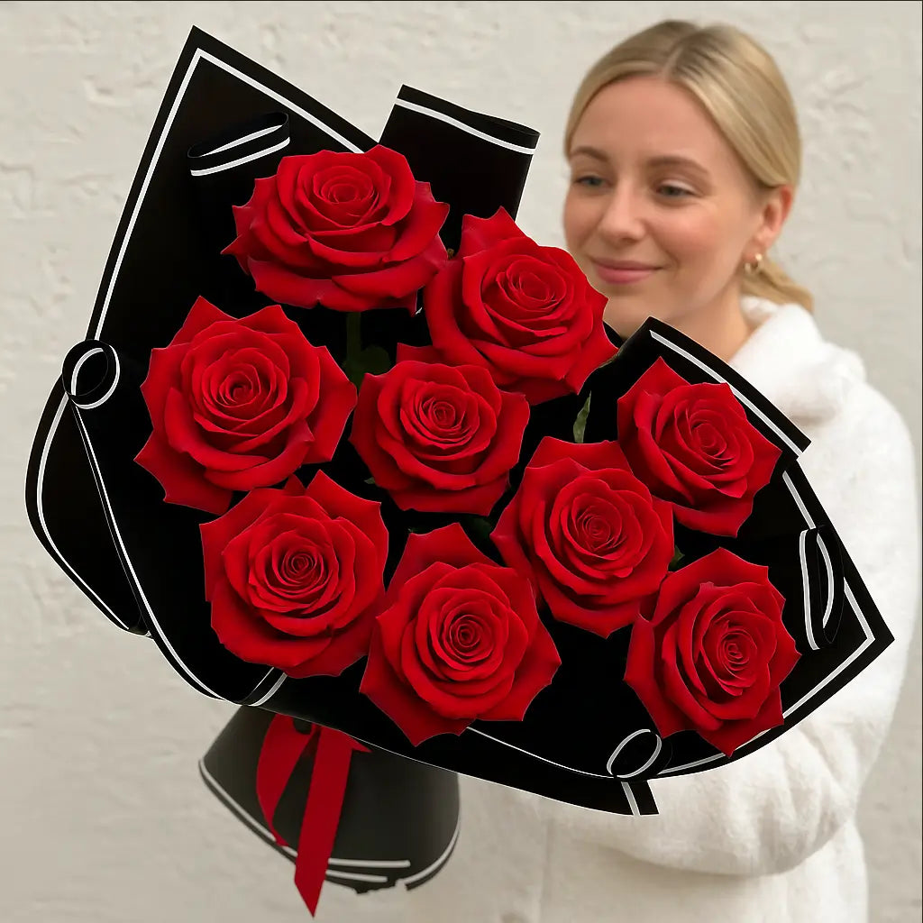 My Valentine bouquet of classic red roses in black luxury wrap — held by smiling blonde woman, Miami delivery