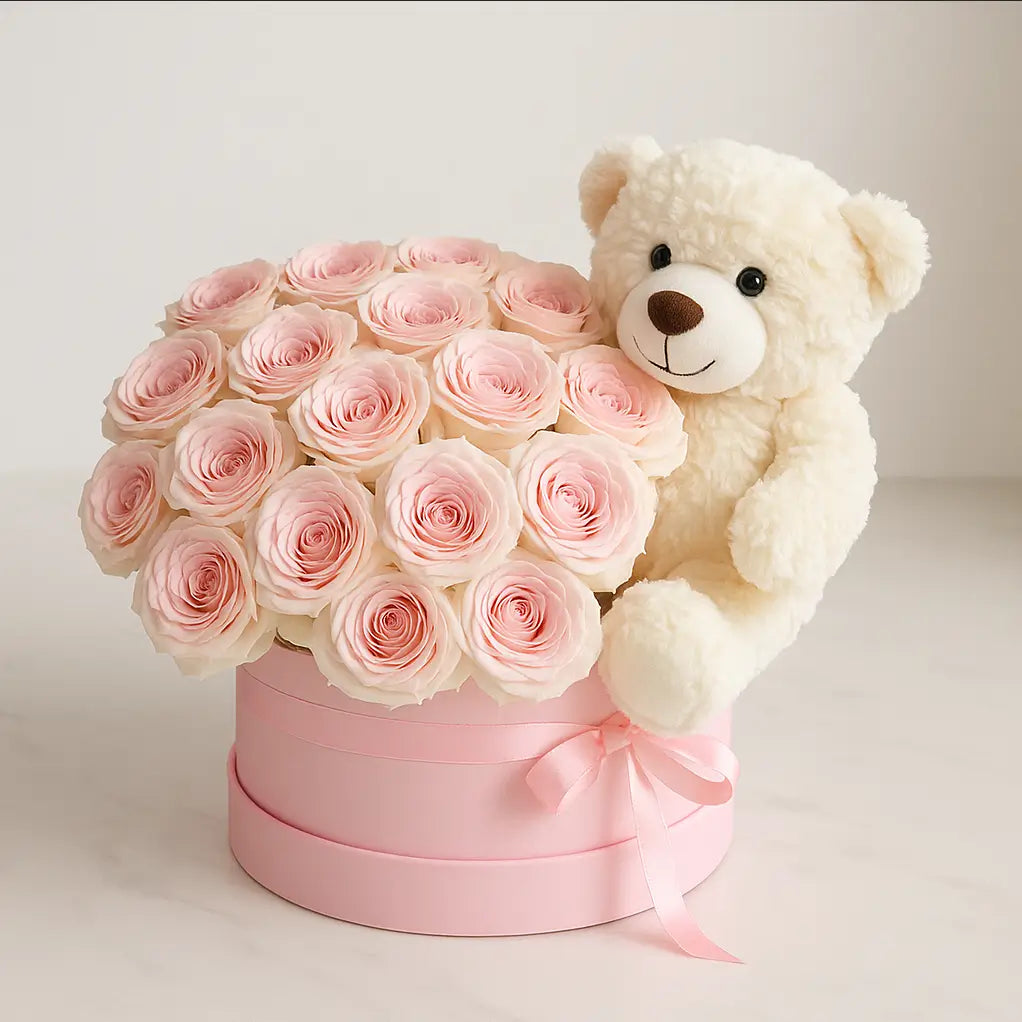 Designer box of pale pink roses with soft white teddy bear on a marble surface — limited luxury gift for romantic occasions