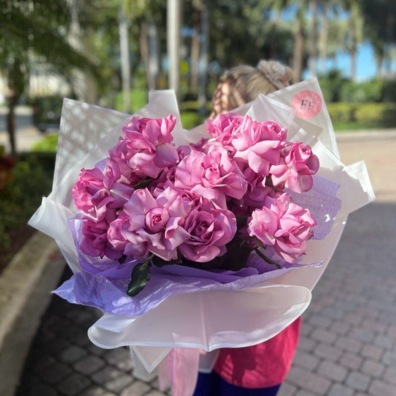 Elegant lavender rose bouquet in violet wrapping held by blonde woman — unforgettable flower gif